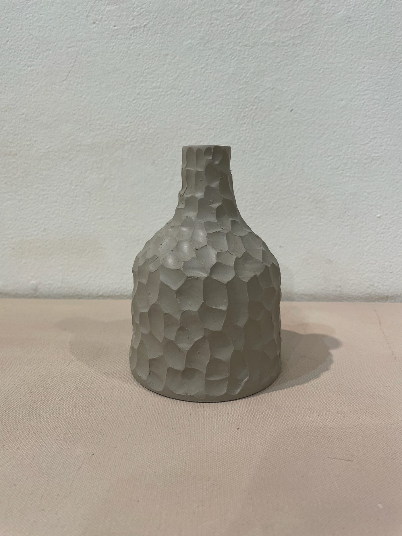 Close-up of hand-carved texture on unfired clay vase