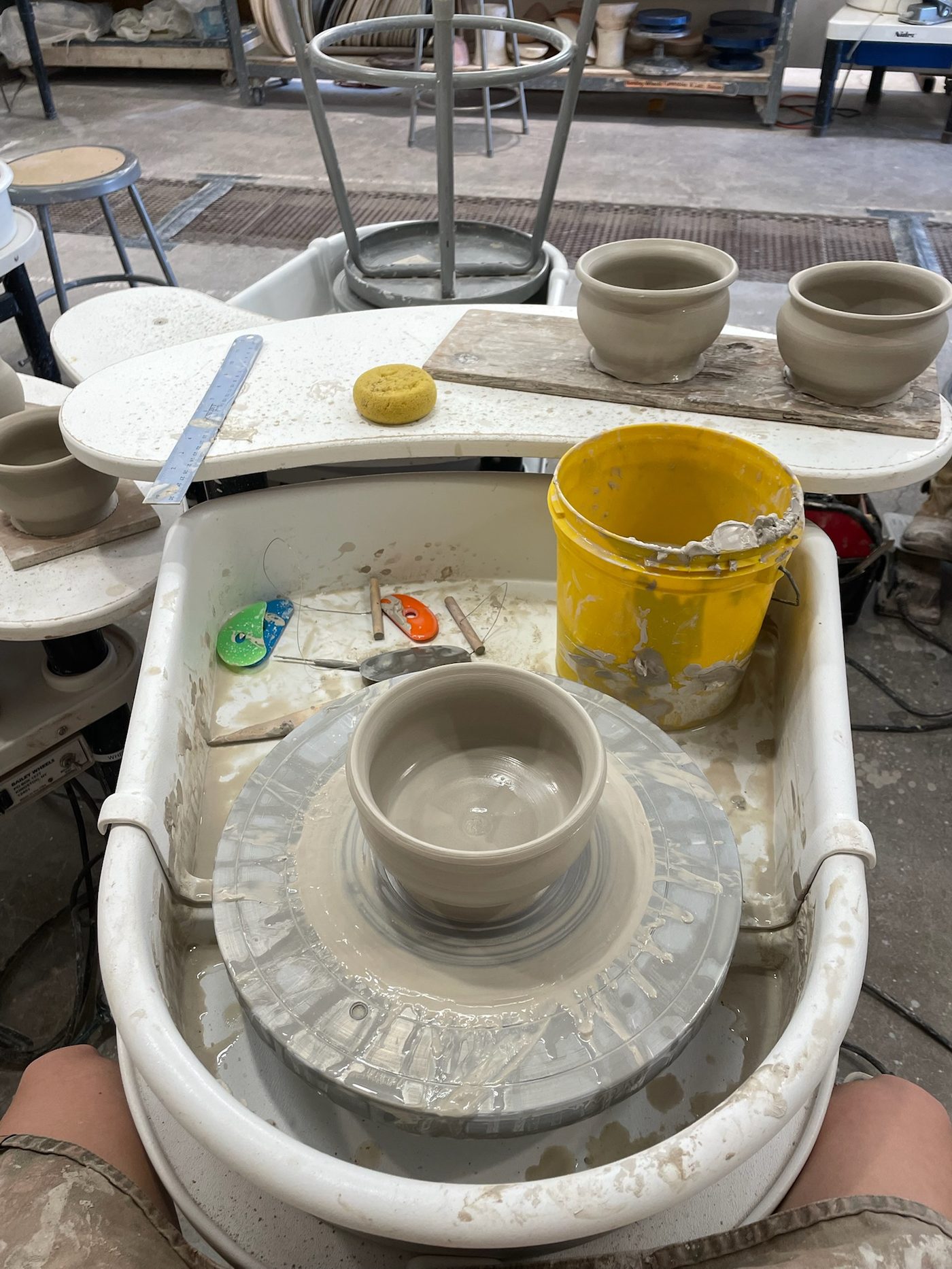 Hands throwing a clay bowl on the pottery wheel